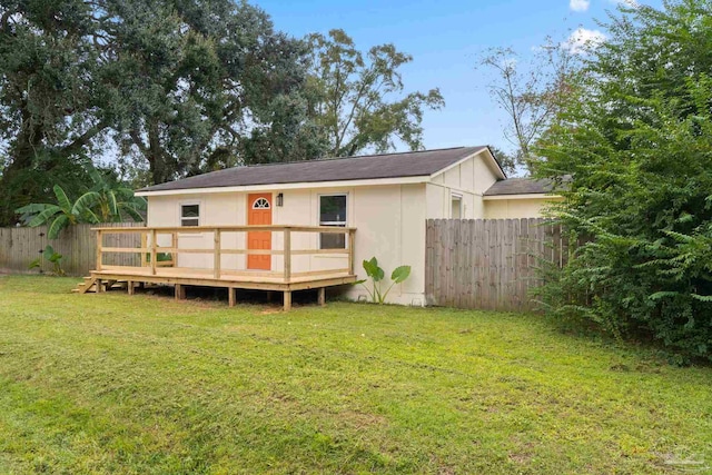 rear view of house with a lawn and a deck