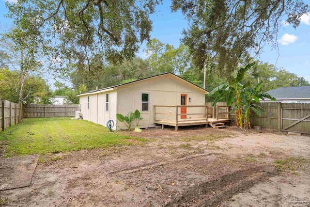 rear view of house with a lawn and a wooden deck