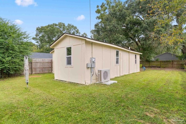 view of outdoor structure featuring ac unit and a yard