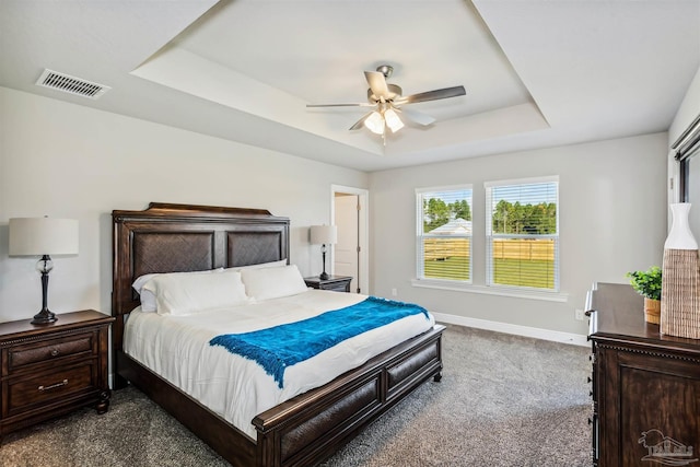 bedroom with carpet flooring, ceiling fan, and a raised ceiling