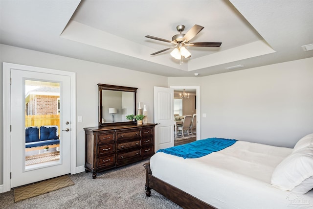 bedroom with ceiling fan with notable chandelier, light colored carpet, a raised ceiling, and multiple windows