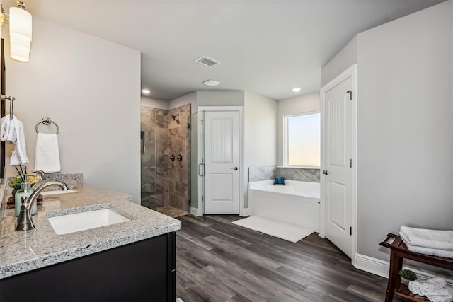 bathroom with plus walk in shower, vanity, and hardwood / wood-style flooring