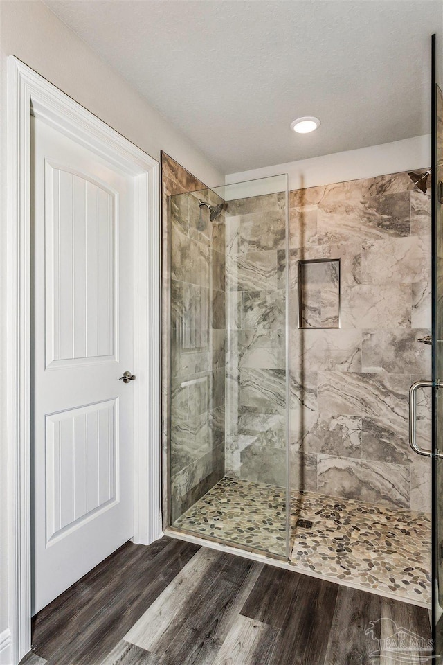 bathroom featuring hardwood / wood-style flooring and walk in shower