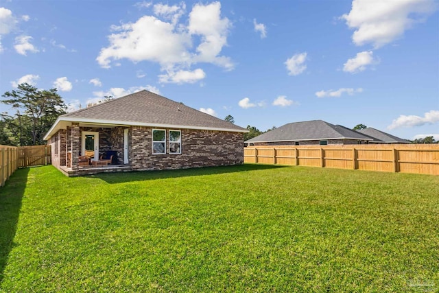 rear view of property with a lawn and a patio area