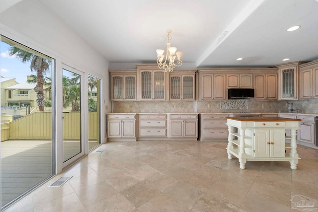 8520 Gulf Blvd Unit 23, Navarre Beach, FL 32566 - kitchen with black microwave, decorative backsplash, a chandelier, a sink, and glass insert cabinets