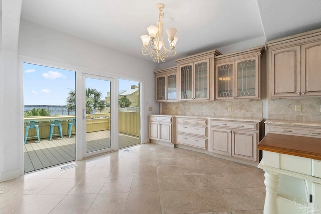 8520 Gulf Blvd Unit 23, Navarre Beach, FL 32566 - kitchen featuring tasteful backsplash, light countertops, a chandelier, glass insert cabinets, and hanging light fixtures