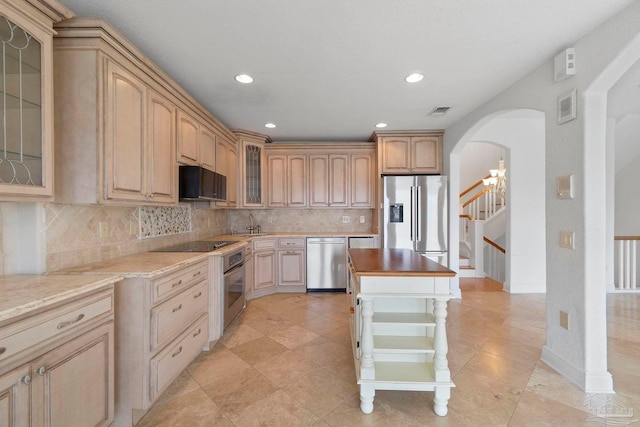 8520 Gulf Blvd Unit 23, Navarre Beach, FL 32566 - kitchen featuring appliances with stainless steel finishes, tasteful backsplash, arched walkways, glass insert cabinets, and a kitchen island