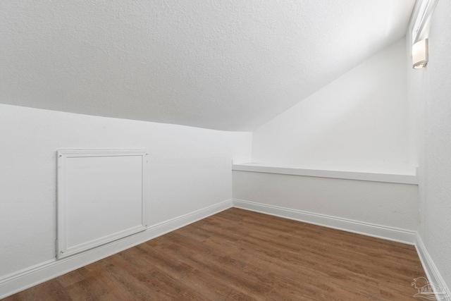8520 Gulf Blvd Unit 23, Navarre Beach, FL 32566 - additional living space with dark wood-style flooring, vaulted ceiling, baseboards, and a textured ceiling