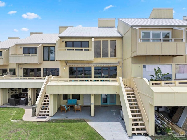 8520 Gulf Blvd Unit 23, Navarre Beach, FL 32566 - rear view of house featuring stairs, a standing seam roof, a patio, metal roof, and a deck