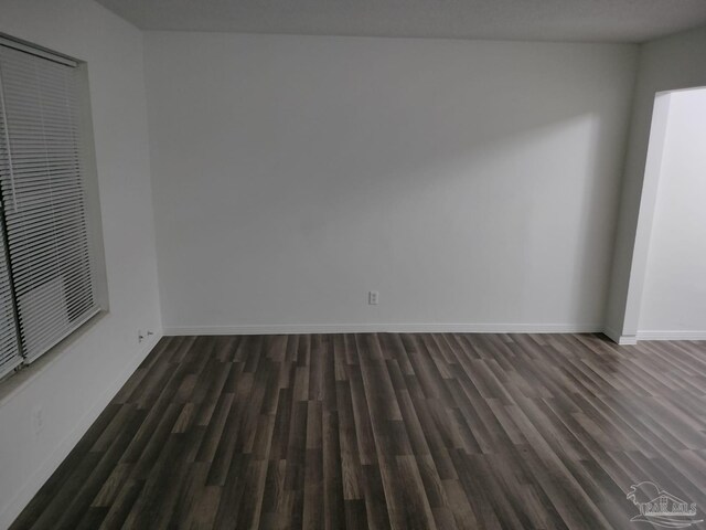 unfurnished room with dark hardwood / wood-style flooring