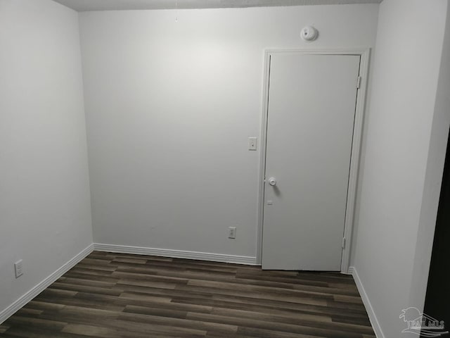 unfurnished room featuring dark wood-type flooring