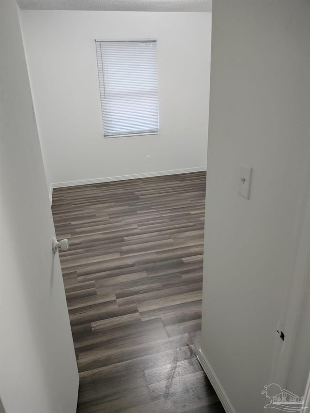 unfurnished room featuring dark hardwood / wood-style floors and a textured ceiling