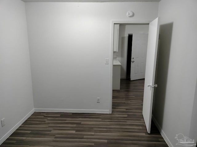 unfurnished room featuring dark wood-type flooring