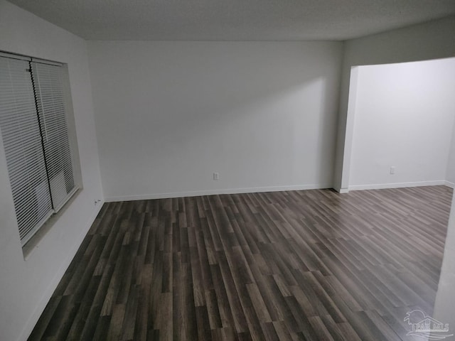 unfurnished room with dark hardwood / wood-style flooring