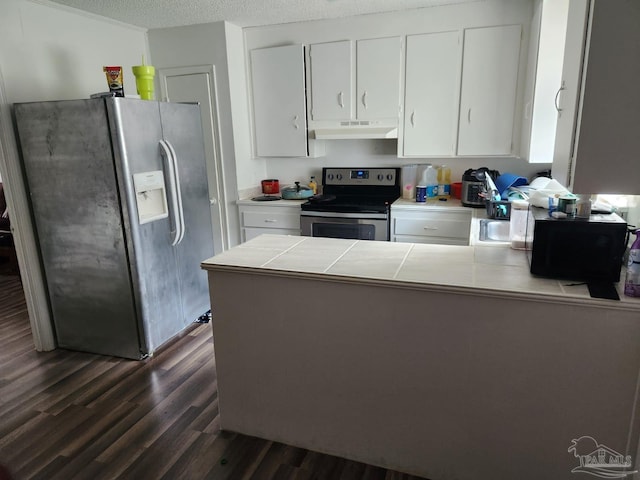 kitchen featuring appliances with stainless steel finishes, a textured ceiling, white cabinets, dark hardwood / wood-style flooring, and tile countertops