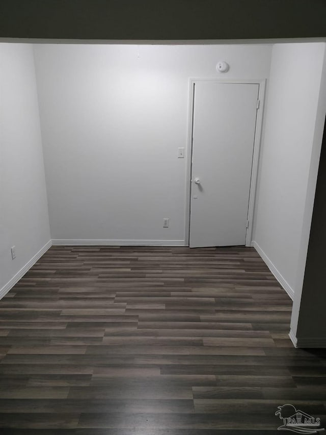 empty room with dark hardwood / wood-style flooring