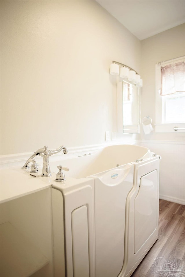 bathroom with wood-type flooring and a bathtub