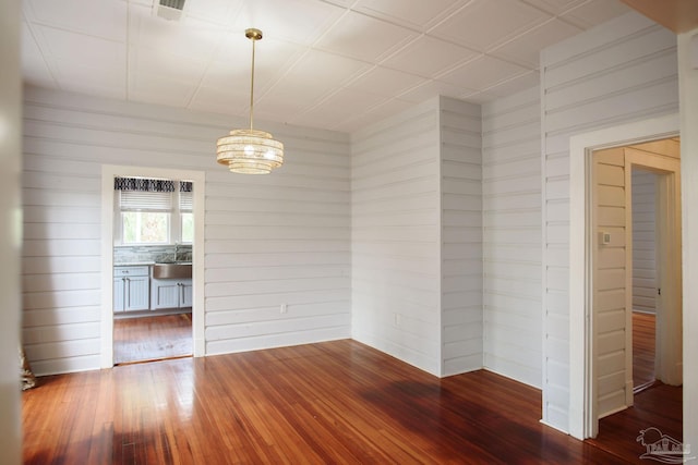 unfurnished room featuring hardwood / wood-style flooring and sink