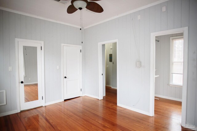 unfurnished bedroom with wood-type flooring and ornamental molding