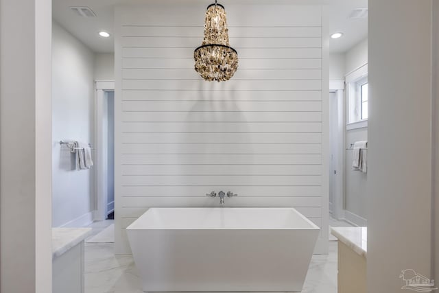 bathroom featuring a bath, vanity, and wood walls