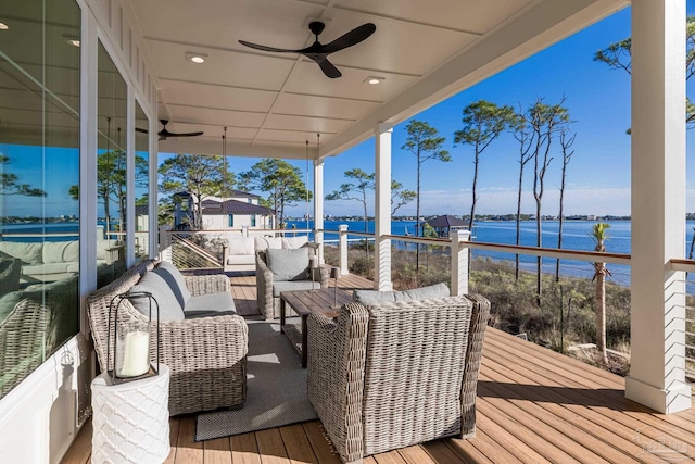 deck featuring outdoor lounge area, ceiling fan, and a water view