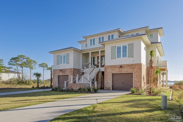 view of front of home with covered porch, a garage, and a front lawn