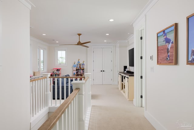 hallway with light colored carpet and crown molding