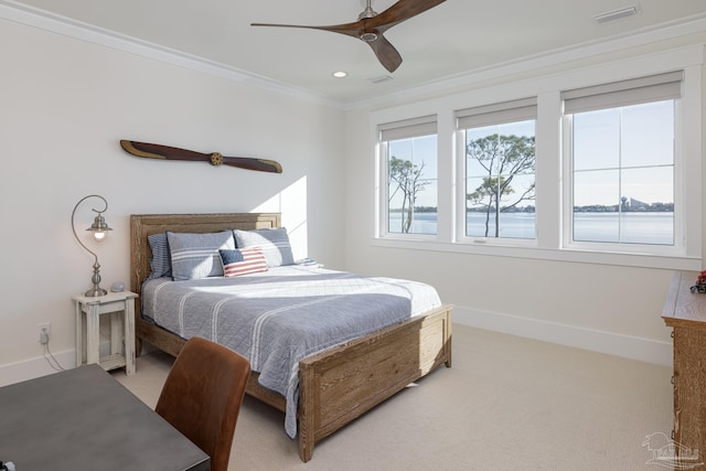 bedroom with carpet floors, ceiling fan, crown molding, and a water view