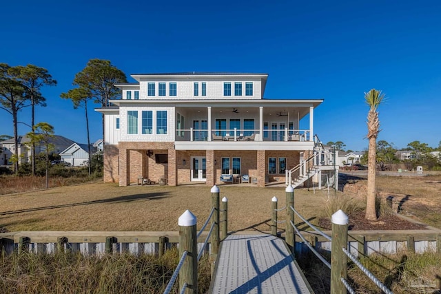 rear view of property with a yard, a balcony, and french doors