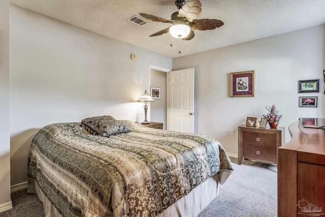 carpeted bedroom featuring a textured ceiling and ceiling fan