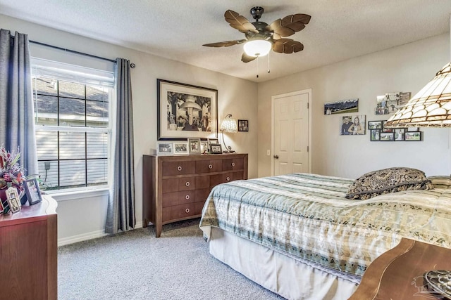 carpeted bedroom featuring ceiling fan and a textured ceiling