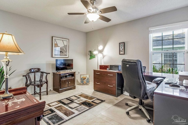 tiled home office featuring ceiling fan and a textured ceiling