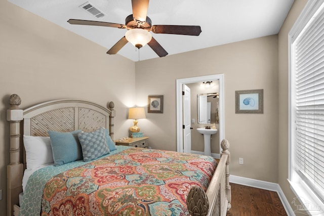 bedroom featuring ensuite bathroom, multiple windows, ceiling fan, and dark hardwood / wood-style flooring