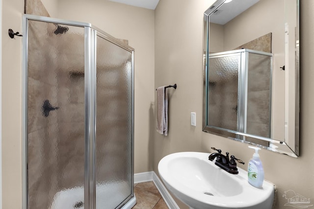 bathroom with tile patterned flooring, walk in shower, and sink