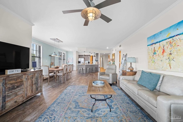 living room with ceiling fan, ornamental molding, and dark hardwood / wood-style flooring