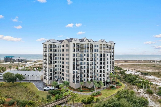 view of building exterior with a water view and a beach view