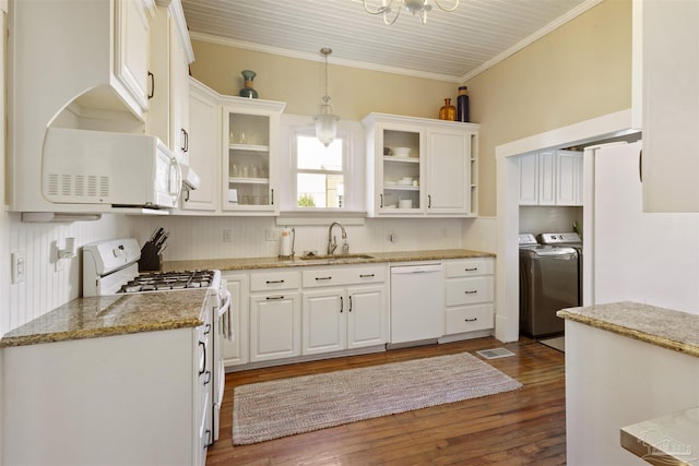 kitchen with white appliances, washer and clothes dryer, sink, decorative light fixtures, and white cabinetry