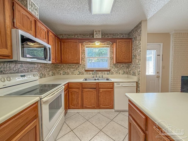 4514 Southpointe Ln, Pensacola, FL 32514 - kitchen featuring white appliances, a sink, a textured ceiling, healthy amount of natural light, and light countertops