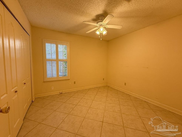4514 Southpointe Ln, Pensacola, FL 32514 - unfurnished bedroom featuring a textured ceiling, a closet, light tile patterned flooring, a ceiling fan, and baseboards
