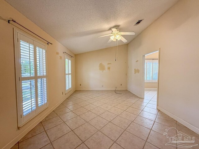 4514 Southpointe Ln, Pensacola, FL 32514 - unfurnished room with vaulted ceiling, healthy amount of natural light, a textured ceiling, a ceiling fan, and light tile patterned flooring