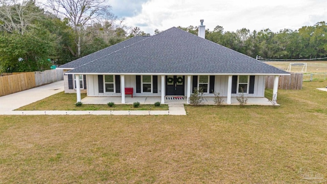 view of front of property featuring a chimney, roof with shingles, fence, a porch, and a front yard