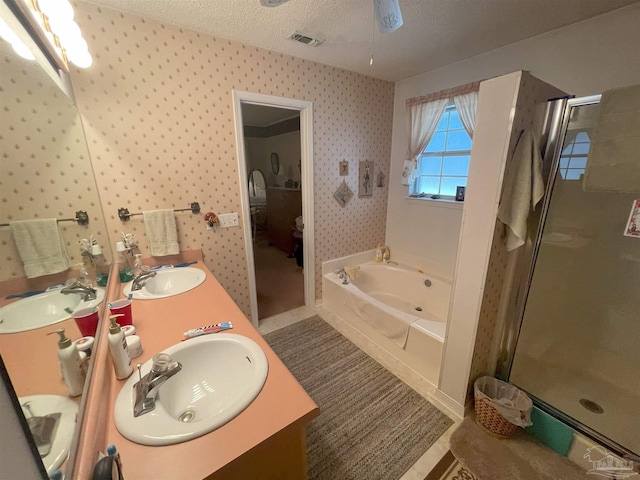 bathroom featuring vanity, ceiling fan, shower with separate bathtub, and a textured ceiling