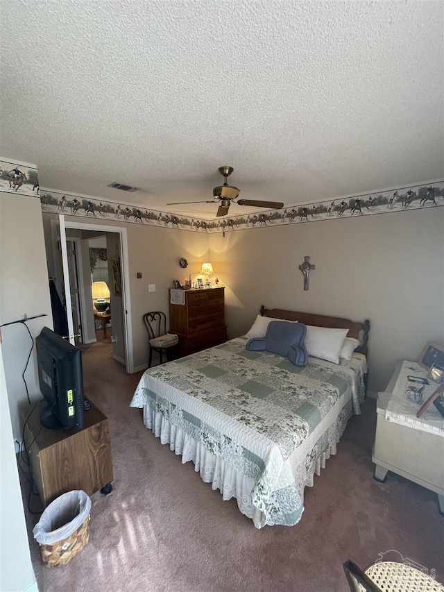 carpeted bedroom with a textured ceiling and ceiling fan