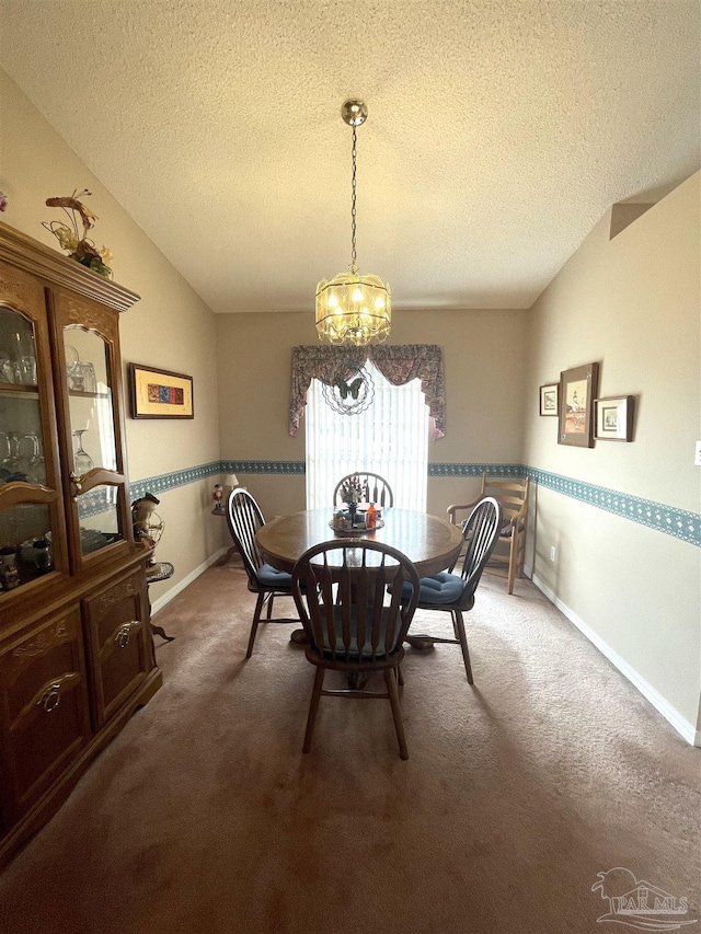 dining room with an inviting chandelier, carpet floors, and vaulted ceiling