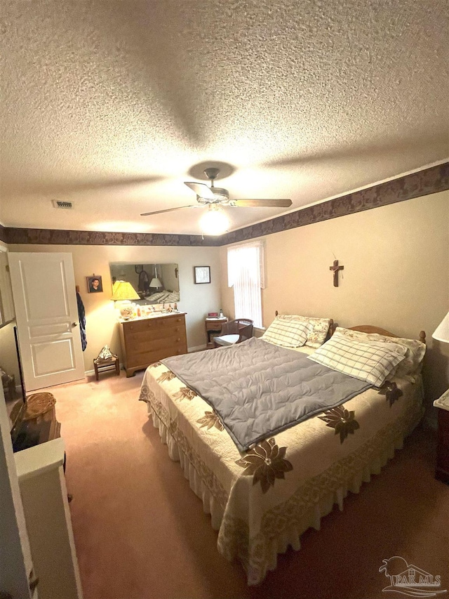 bedroom featuring a textured ceiling, ceiling fan, and carpet flooring