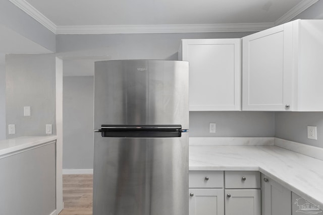 14100 River Rd Unit 223B, Pensacola, FL 32507 - kitchen featuring freestanding refrigerator, light wood finished floors, crown molding, white cabinets, and light stone countertops