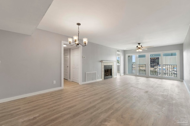 14100 River Rd Unit 223B, Pensacola, FL 32507 - unfurnished living room with baseboards, light wood-style floors, a chandelier, ceiling fan, and a tile fireplace