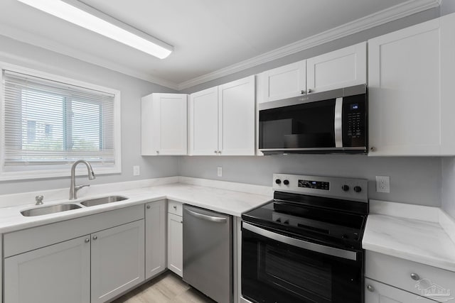 14100 River Rd Unit 223B, Pensacola, FL 32507 - kitchen featuring appliances with stainless steel finishes, a sink, ornamental molding, light stone countertops, and white cabinetry