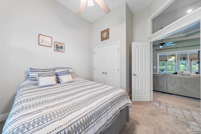 carpeted bedroom featuring ceiling fan, a closet, and a high ceiling