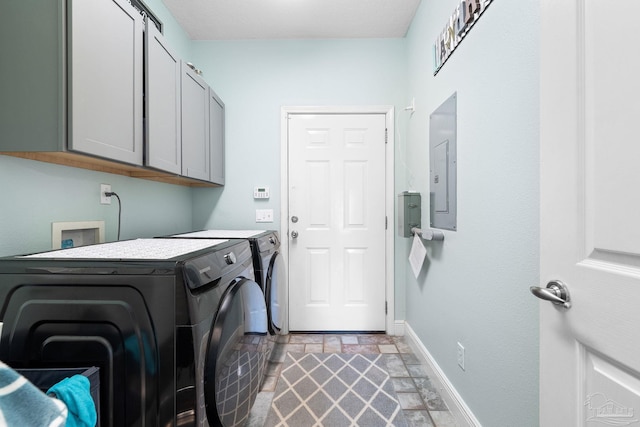 clothes washing area with independent washer and dryer, electric panel, and cabinets